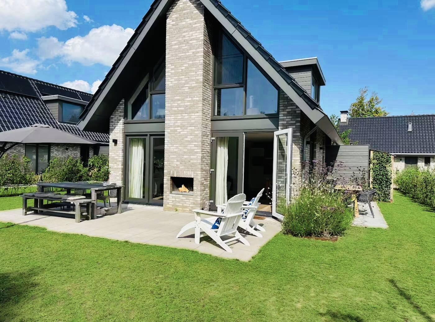 Het huis met tuin, terras en loungestoelen
